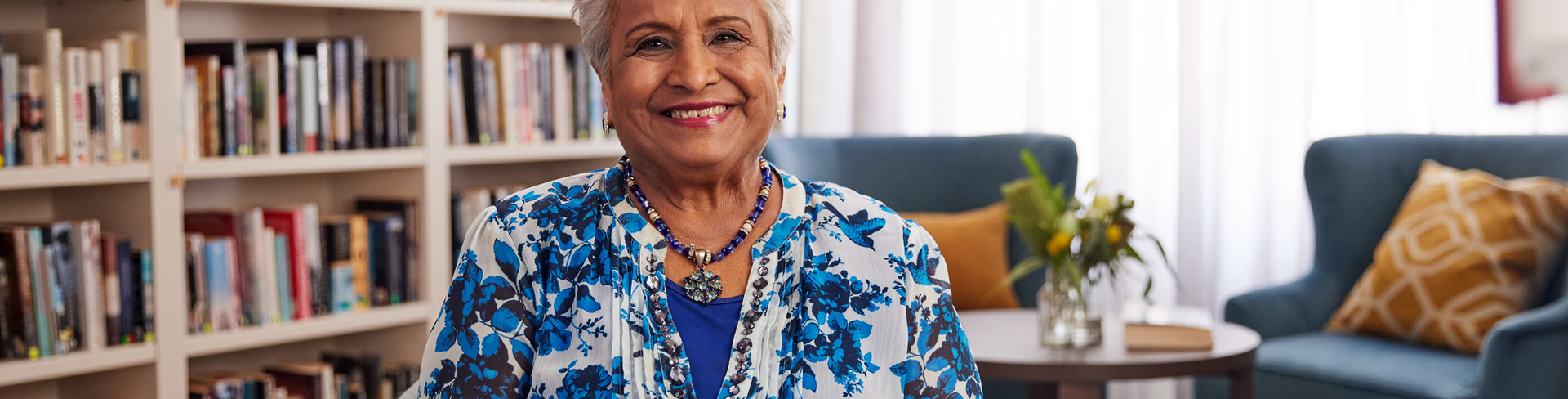 Classic Residences resident Satya sitting on a chair and smiling to the camera