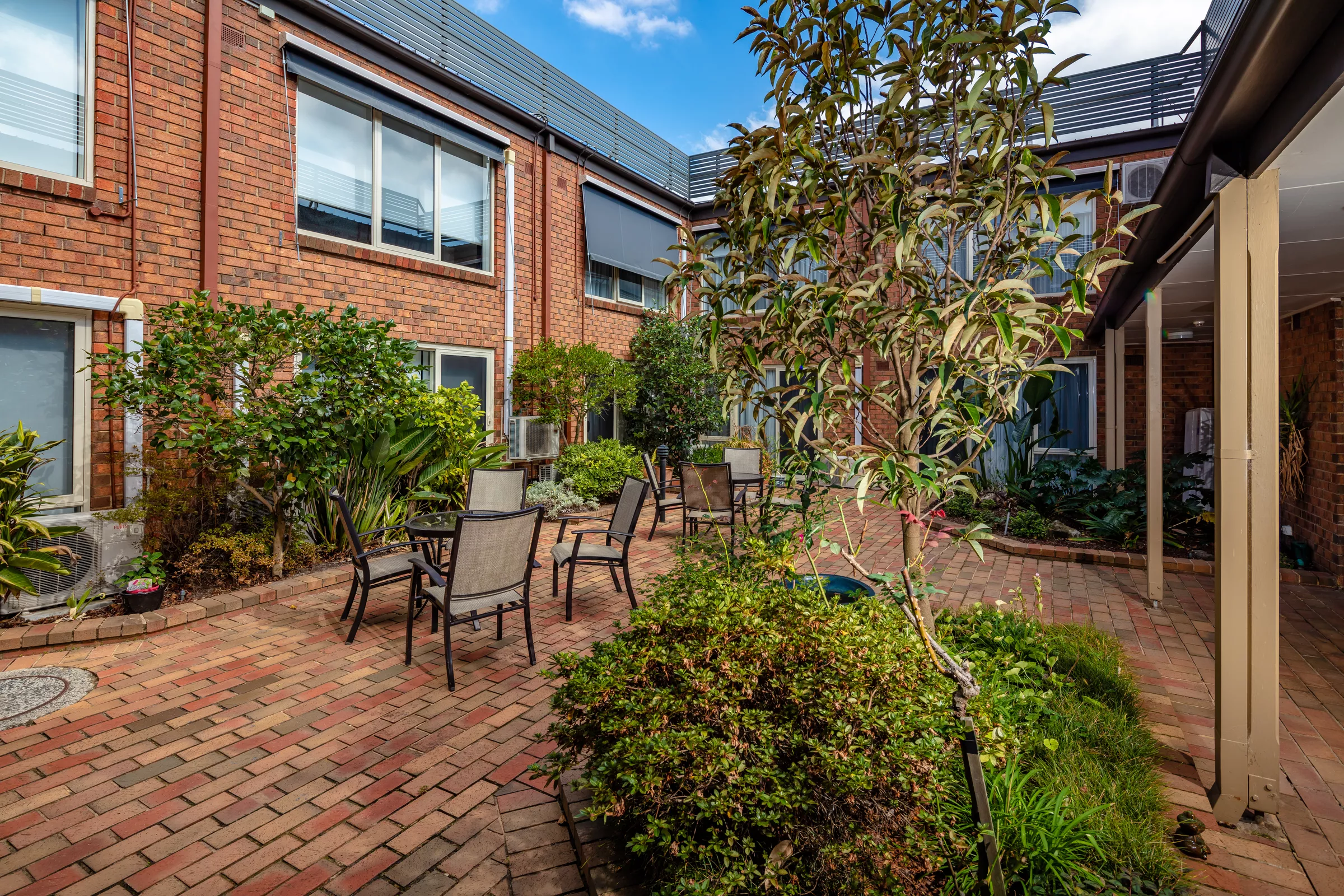 Highvale Village courtyard amongst building with courtyard garden, table and chairs