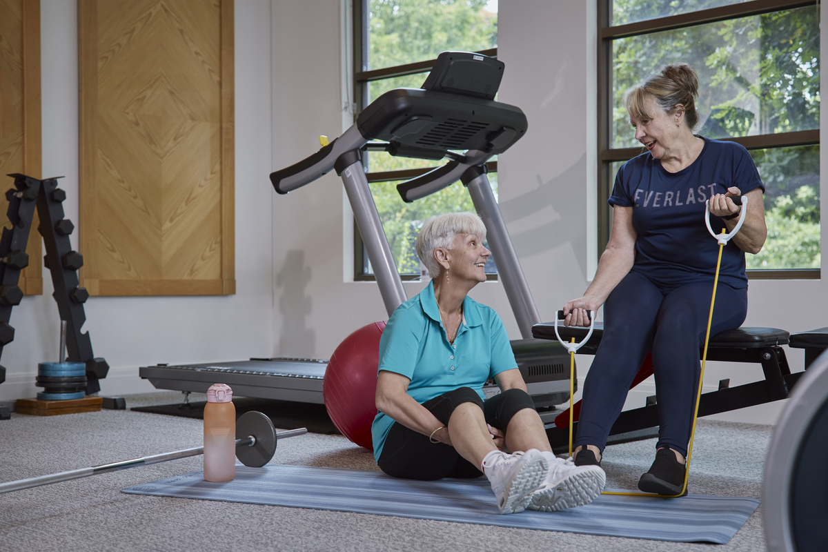 two women sitting and chatting in the gym
