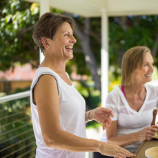 Two women smiling as they enjoy the wellness revolution for seniors from the benefits of retirement community living.