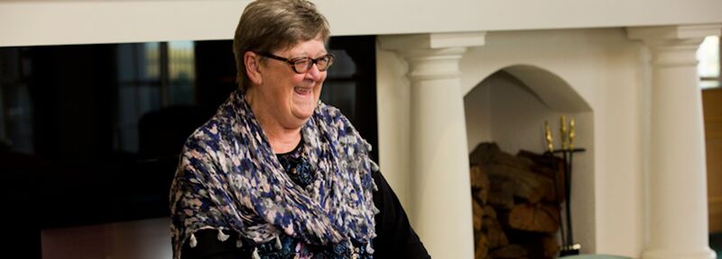 Williamstown resident Ann laughing in front of the fireplace