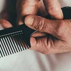 Barbers on a mission, a picture of an old hand holding a comb, a barbers is a good place for people to chat
