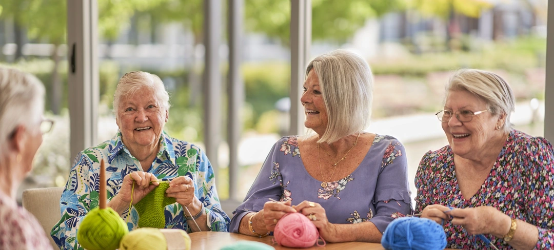 A group of seniors knitting and enjoying each other's company.