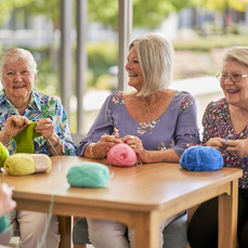 A group of seniors knitting and enjoying each other's company.