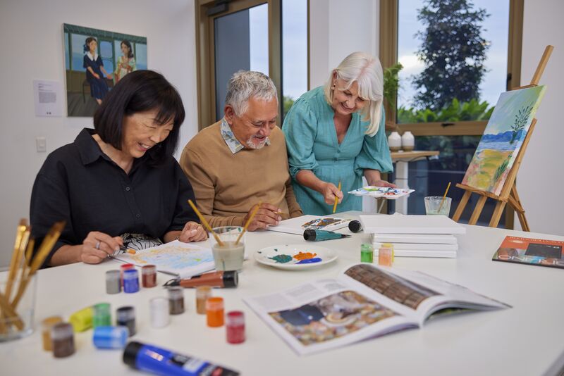 Three residents painting together