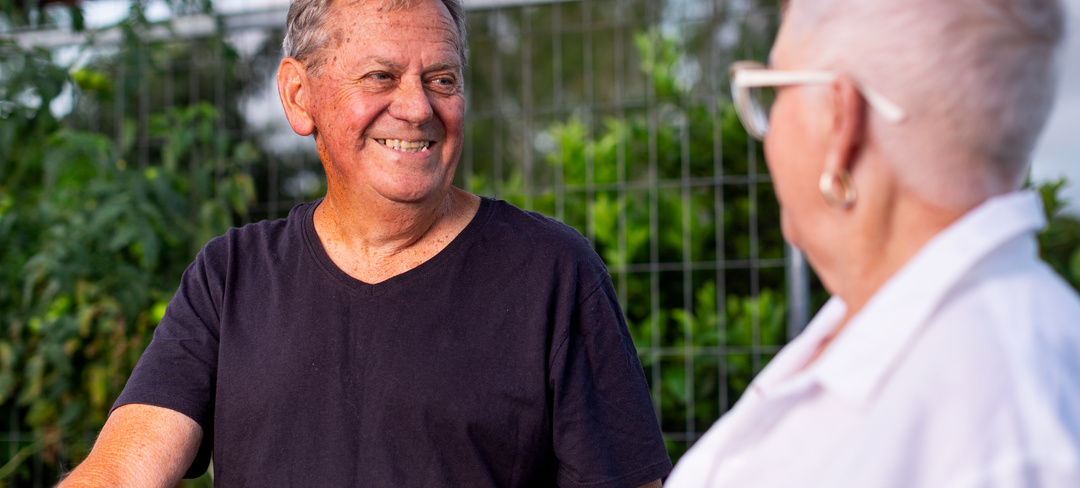 A male and a female resident of Bellflower retirement resort smiling at each other
