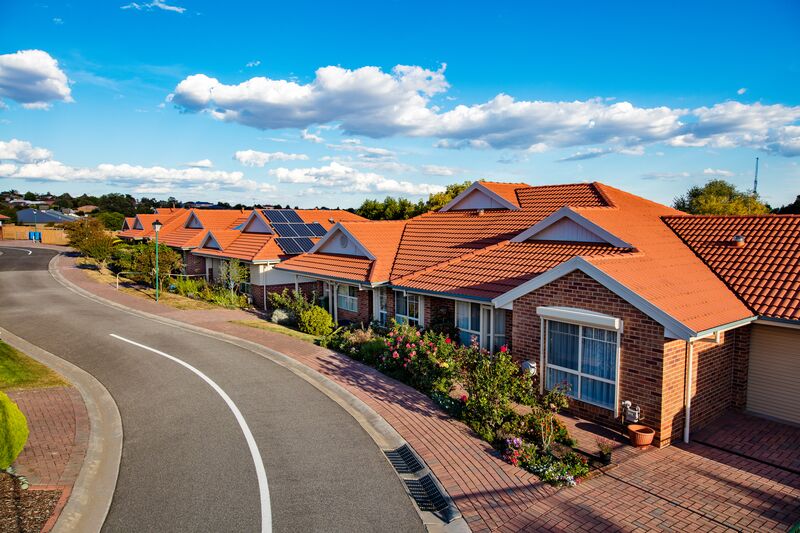 Fiddlers Green aerial photo of village road lined by houses and trees