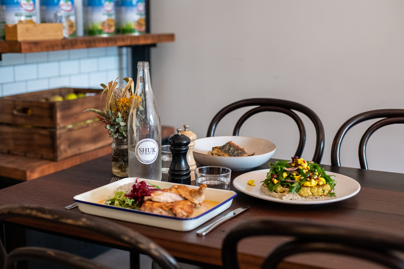 Shuk Restaurant tablescape with food and drinks