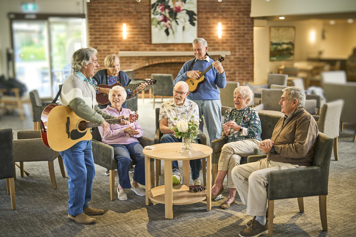 A group of seniors having a great time singing and playing musical instruments.