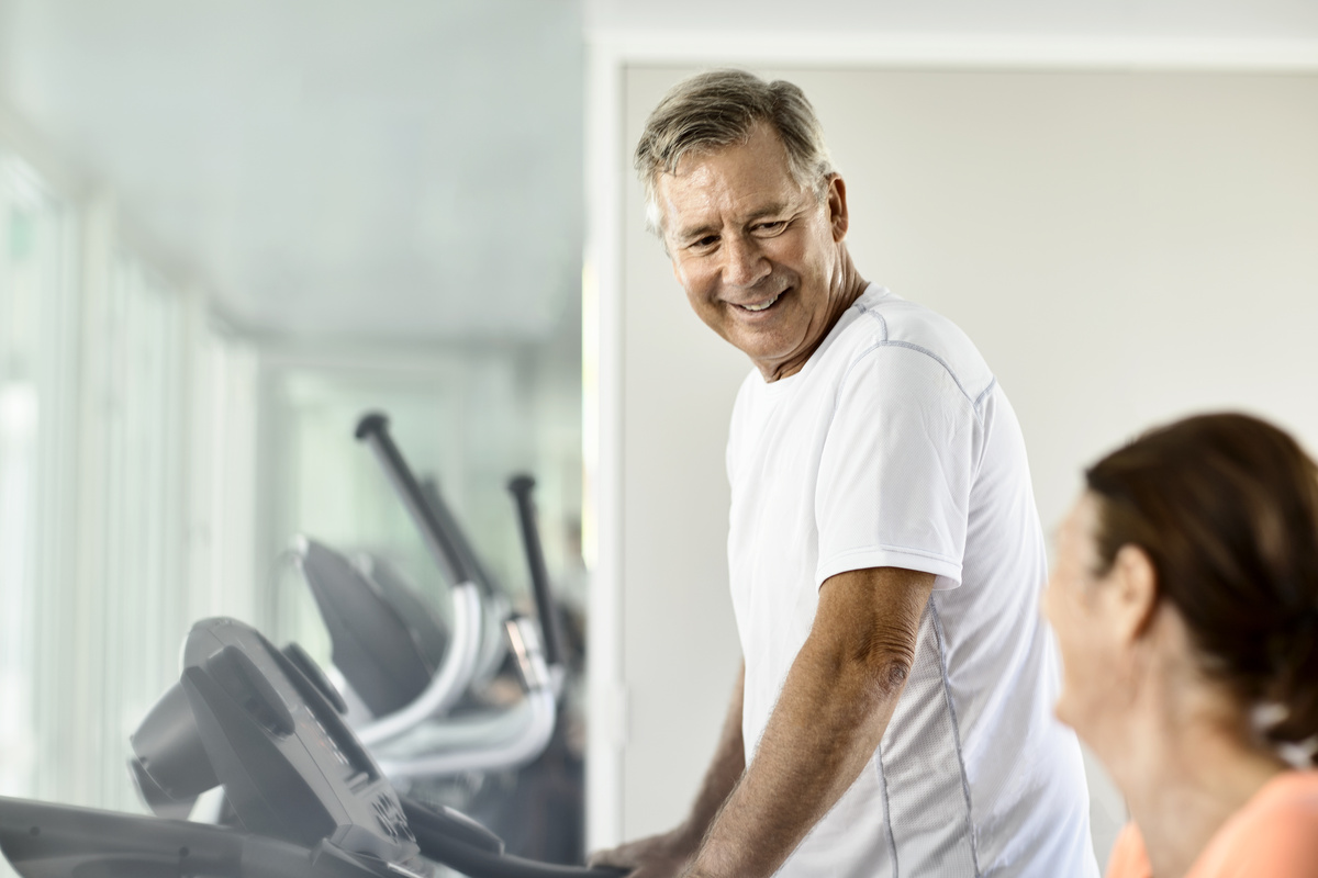Senior man with coach at the gym