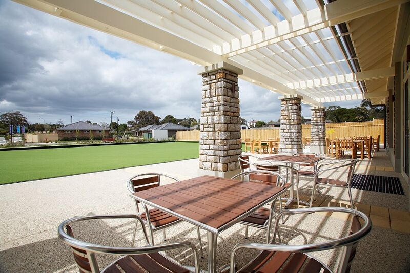 Martha's Point covered terrace with seating beside building looking over bowling green