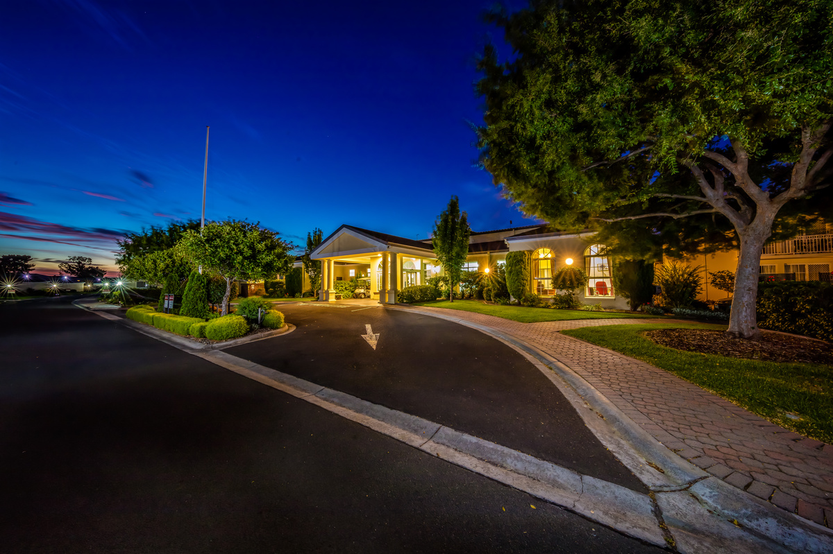 Port Phillip Village night view of street view over landscaping looking towards main entrance