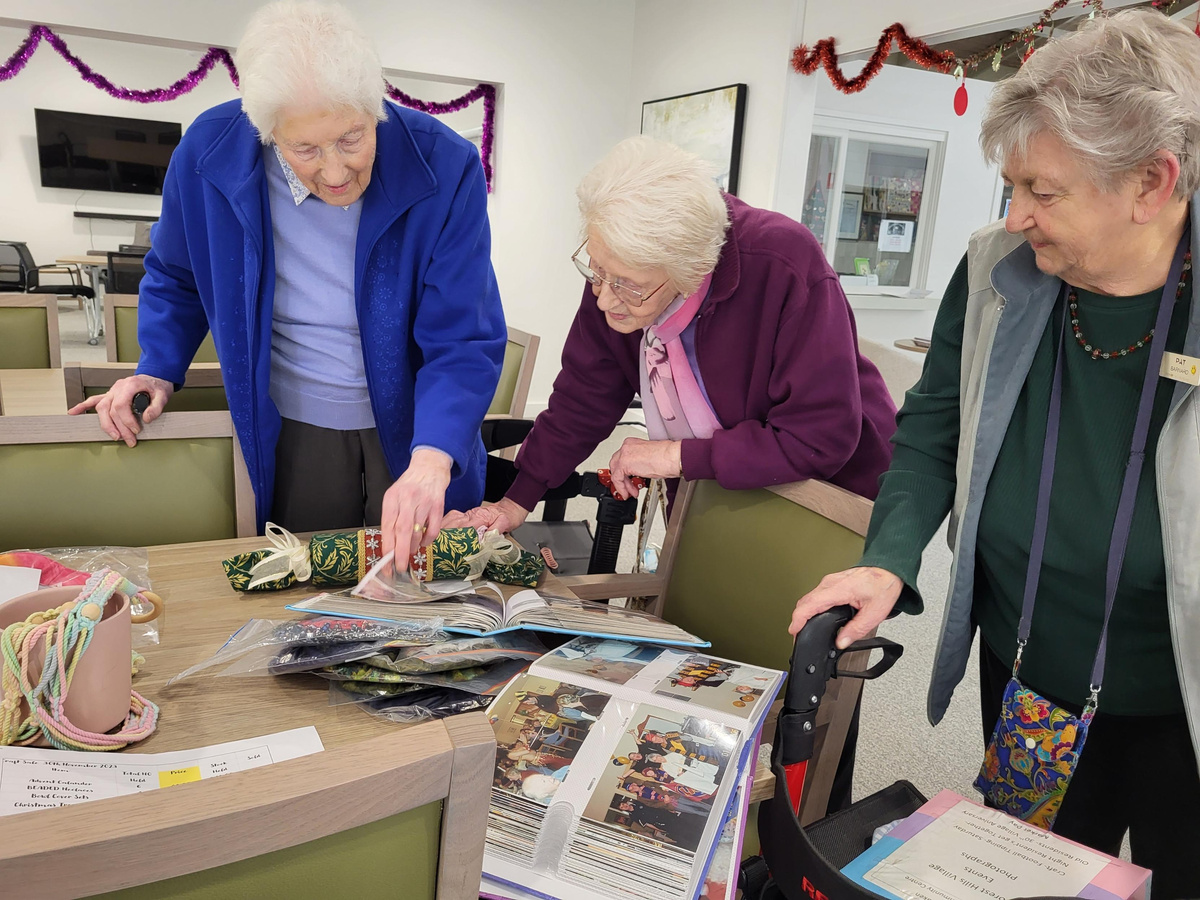 Gwen (left), Nancy (middle) and Pat going through photo albums together