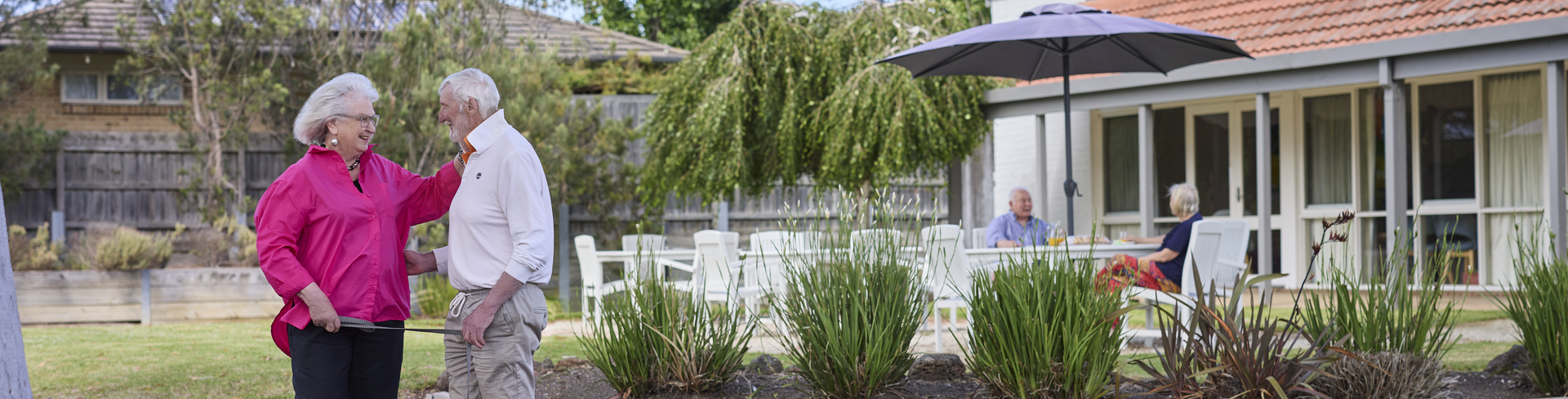 A couple with a dog standing in front of a villa at Koorootang Court retirement village