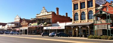 A main street in Kalgoorlie, Western Australia, lined with historic buildings dating back to the early 1900s.