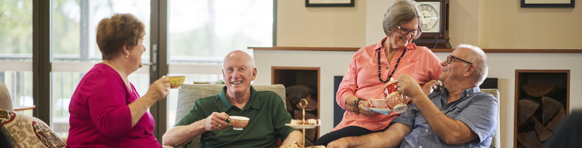 Four residents sitting in the community centre and having afternoon tea