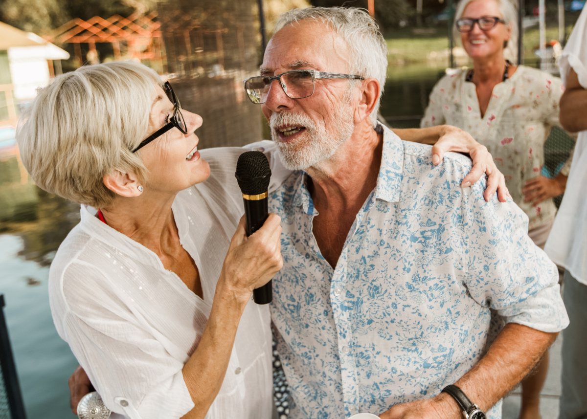 A male and a female retirement village resident singing karaoke together