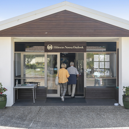 Two seniors walking into the community centre at Hibiscus Noosa Outlook