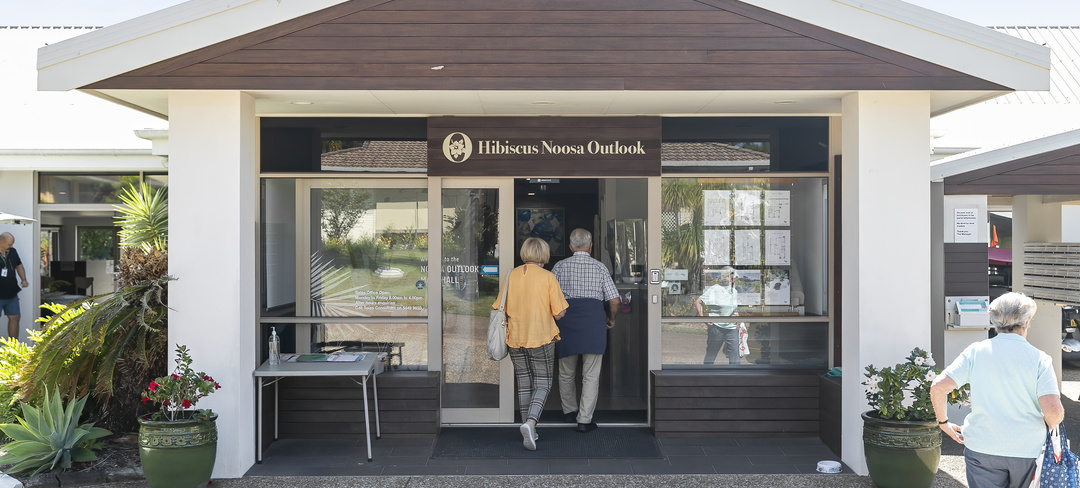 Two seniors walking into the community centre at Hibiscus Noosa Outlook