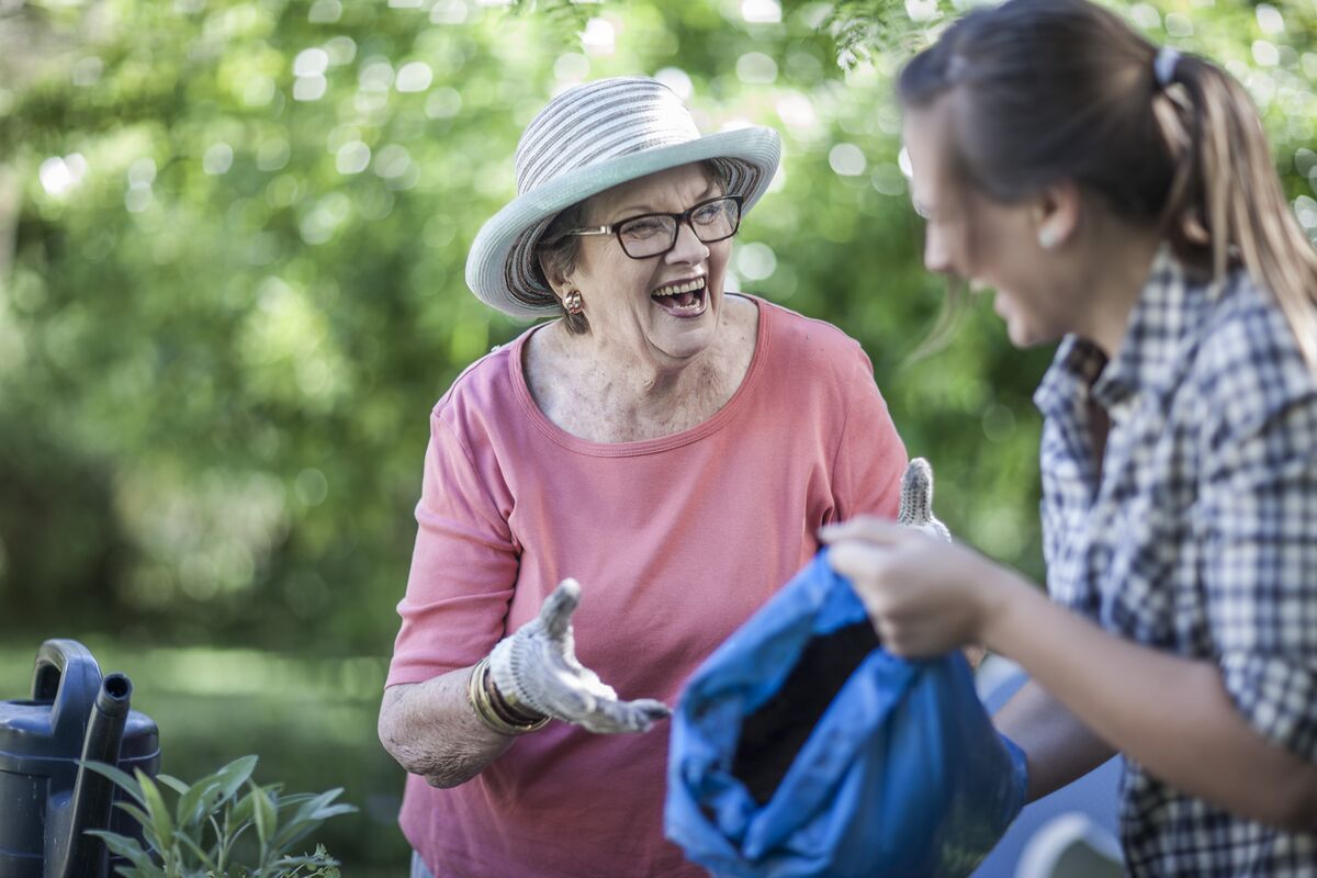 Two women laughing and gardening together