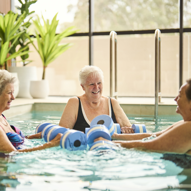 A woman swimming in an indoor pool smiling