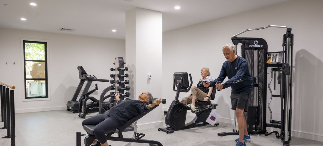 Three older adults working out in a gym at a retirement village