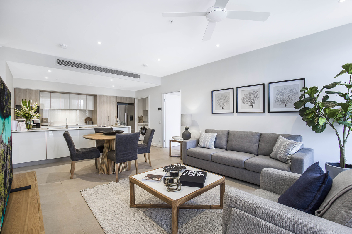 An open-plan living area with a dining area and kitchen in a retirement village villa