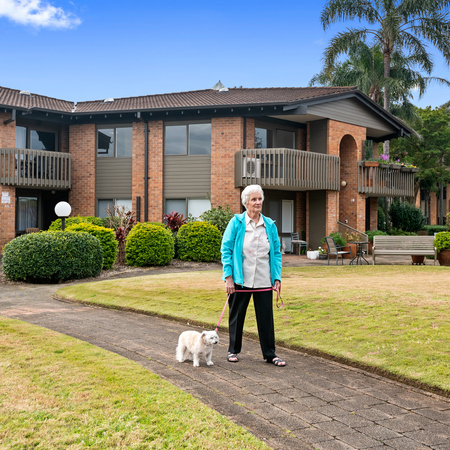 Dee Why Gardens Village interior gardens with a resident walking a white dog