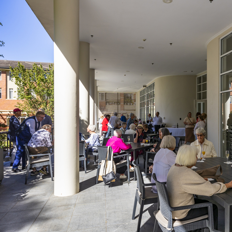An elderly lady laughing to the camera at an event