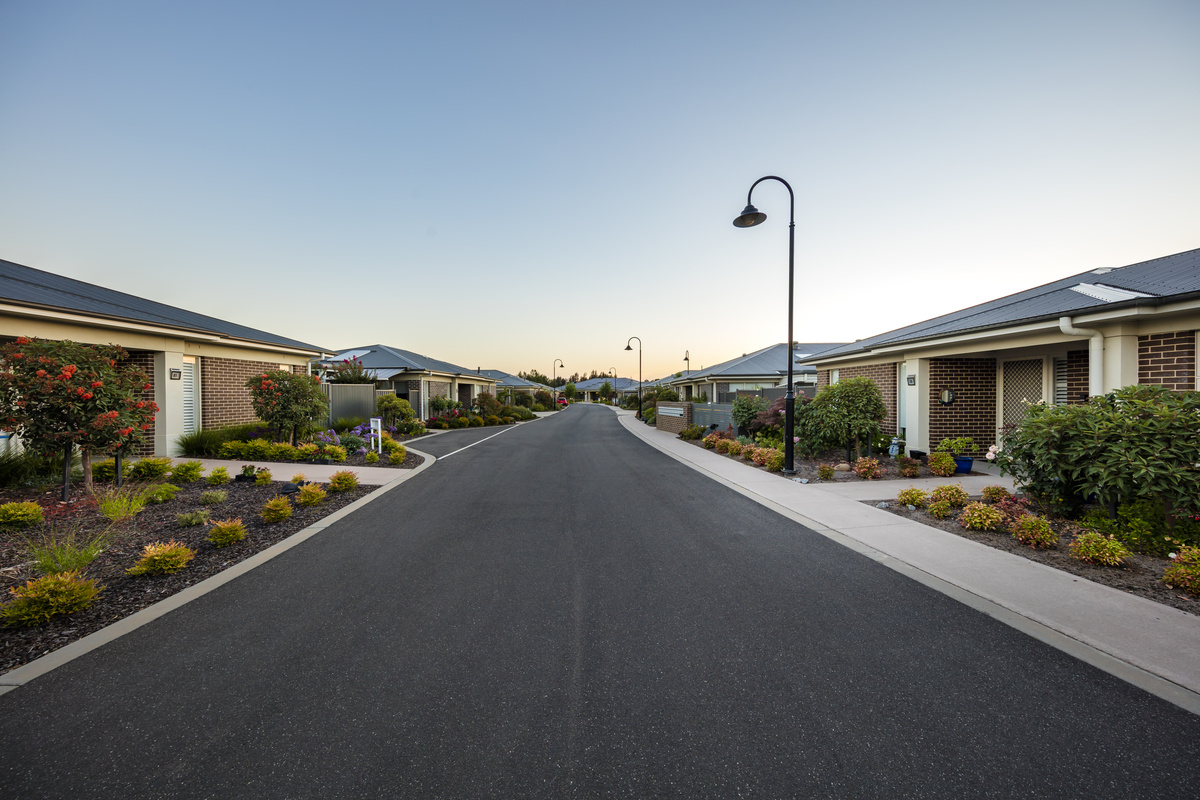 The Links at Waterford village roadway with lamp posts, maintained gardens and brick houses