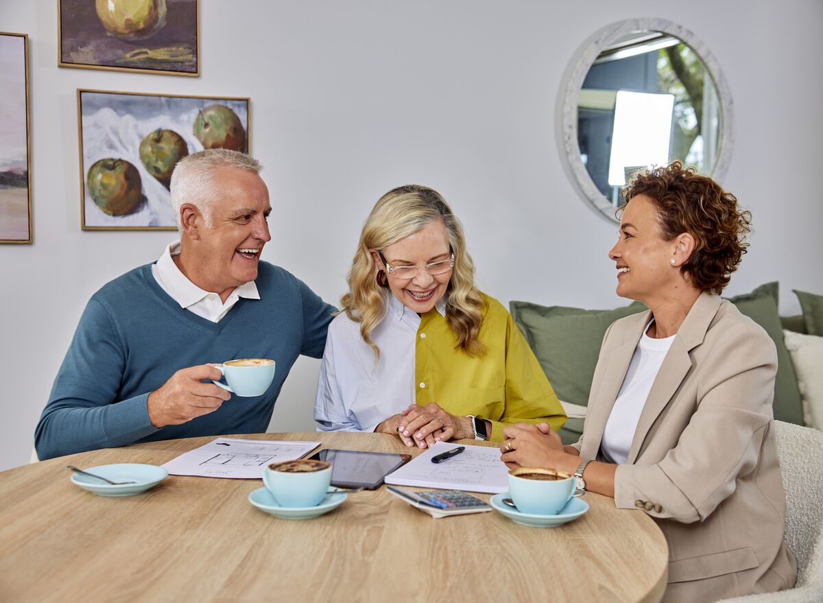A couple speaking to a sales manager about retirement living costs