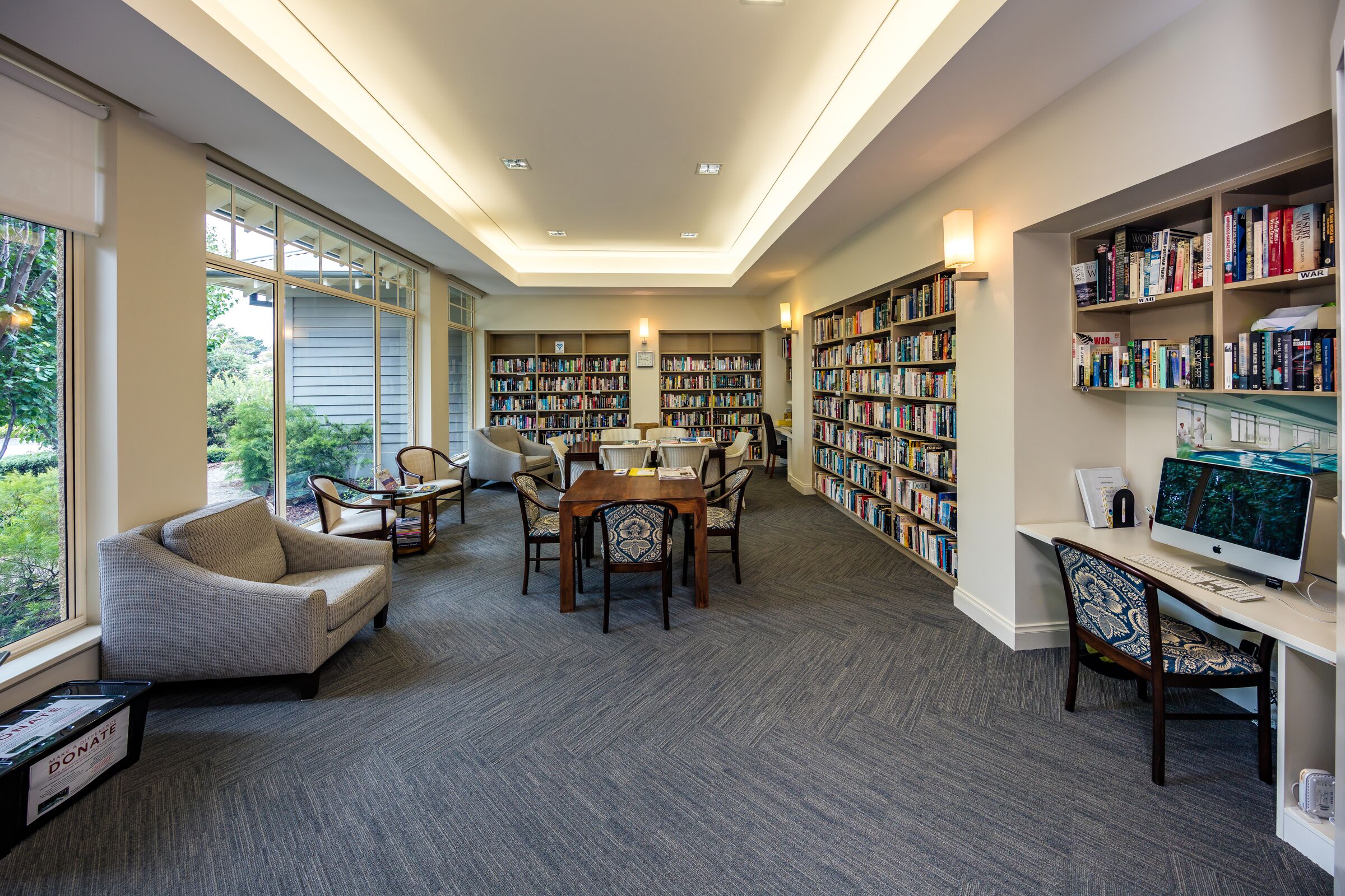 Martha's Point library room with well stocked bookcases, seating and computer