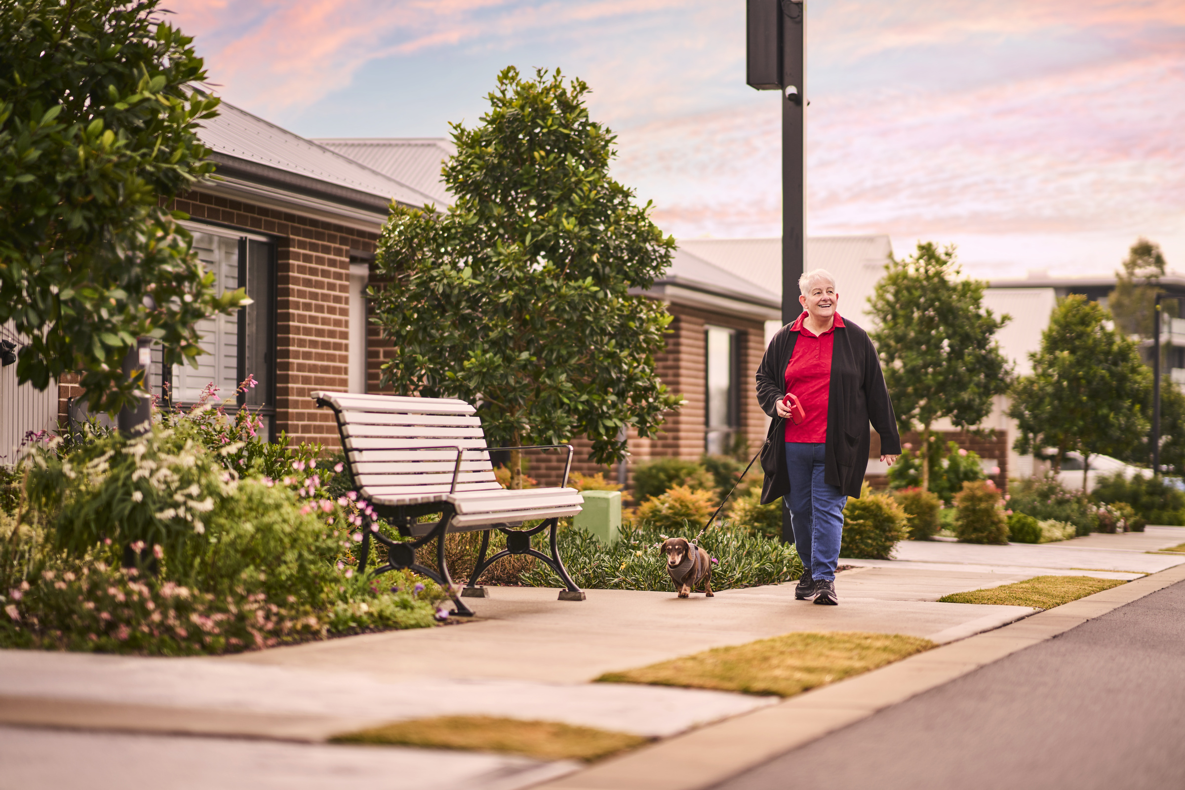Kingfisher Grove Village Resident walking pet next to villa's 