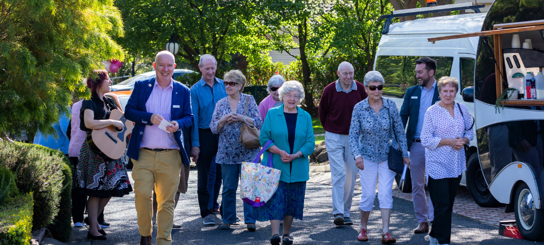 Lincoln walking through a Keyton village with residents and visitors