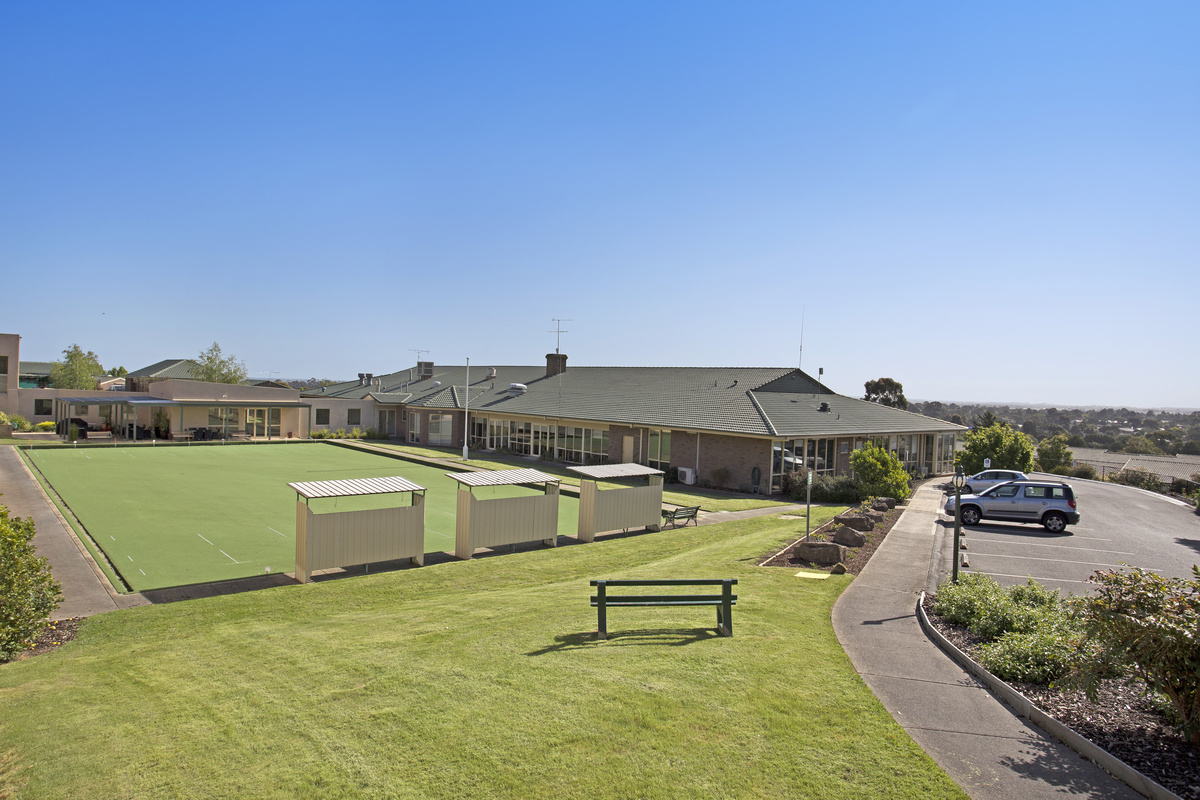 Meadowvale Village bowling green with shade and seating, green located next to main building and near parking