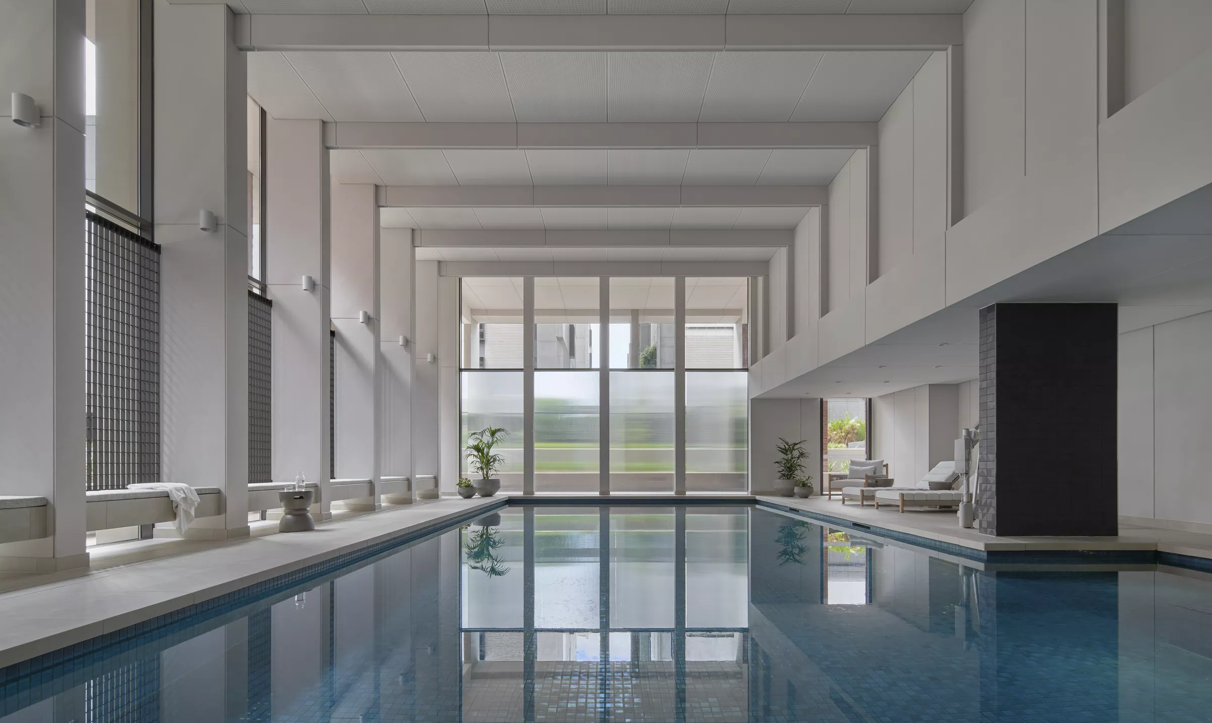 Ardency Kennedy Place larged tiled indoor swimming pool with poolside seating