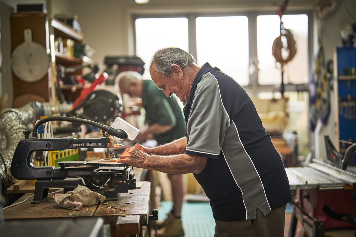 A male retirement village resident working in the hobby shed of the village