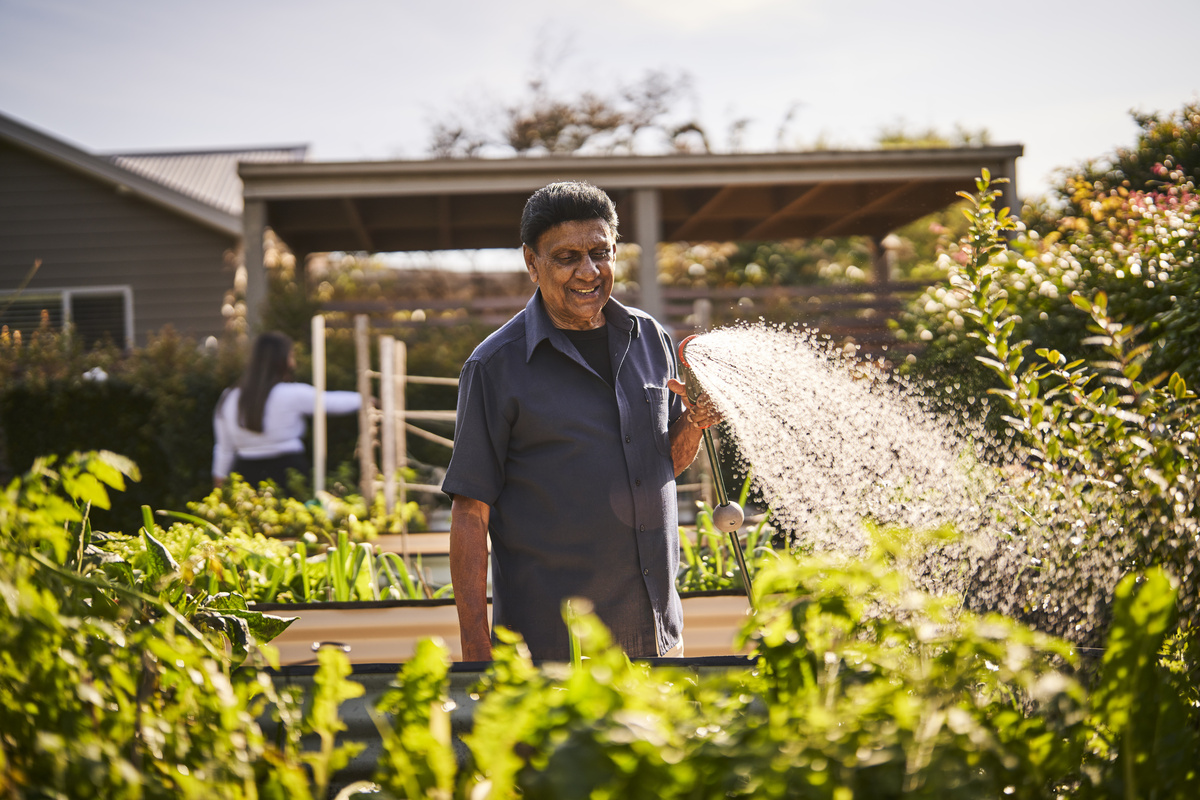 Nelsons Grove resident watering the veggie garden