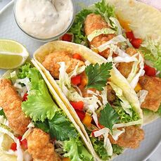 Tasty and zesty fish tacos sitting on a plate. 