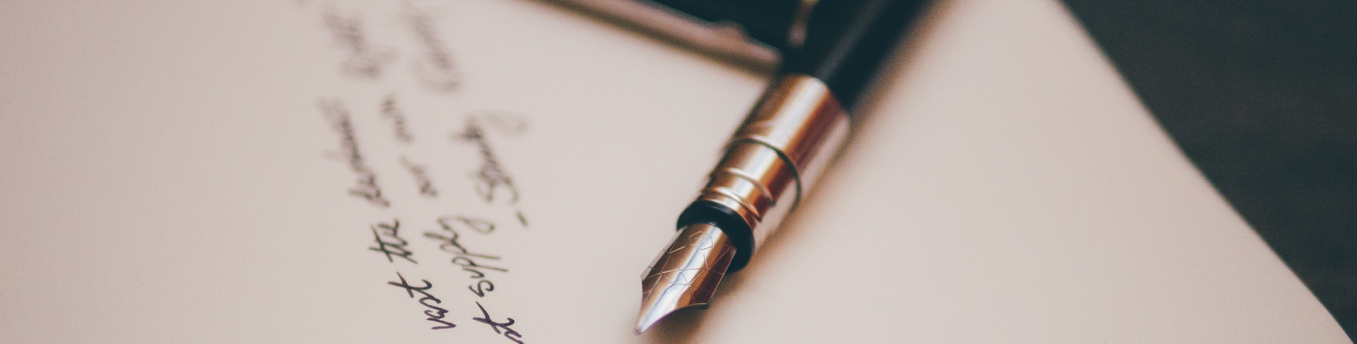 Black and silver fountain pen lying on a piece of paper with a poem written on it
