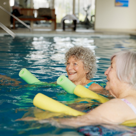 Three elderly ladies enjoying aqua aerobics in the water