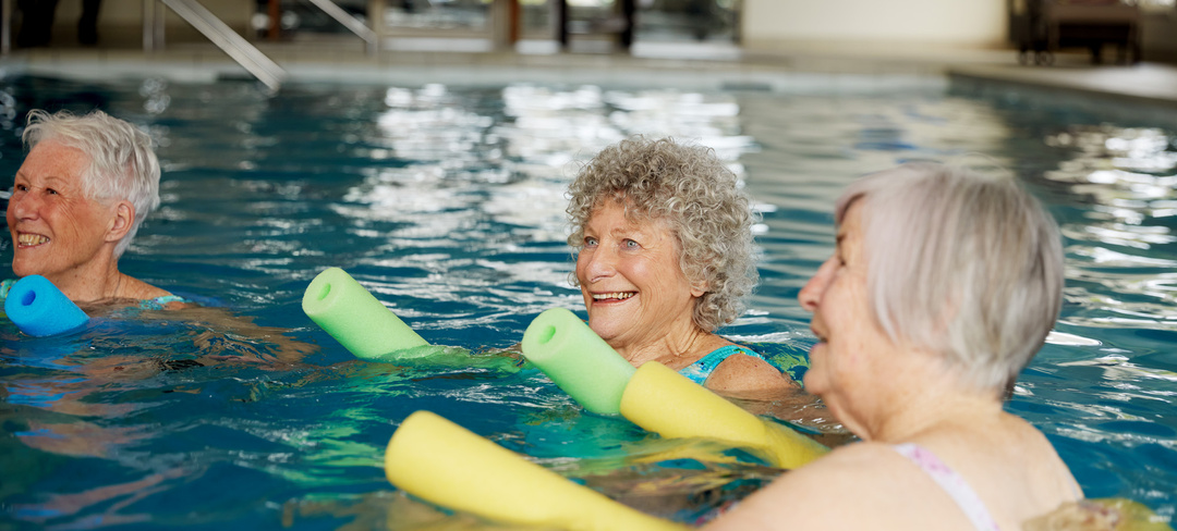 Three elderly ladies enjoying aqua aerobics in the water