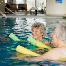 Three elderly ladies enjoying aqua aerobics in the water