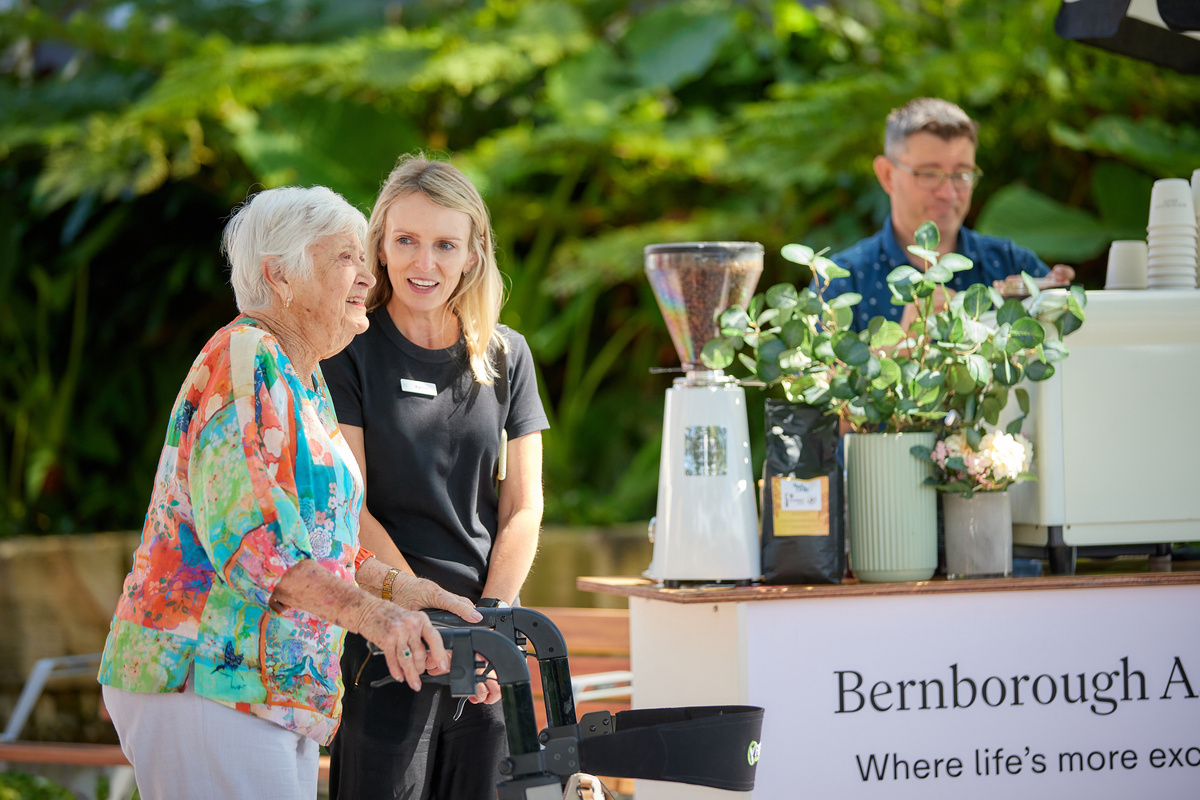 A Keyton staff talking to a senior lady on a walker 