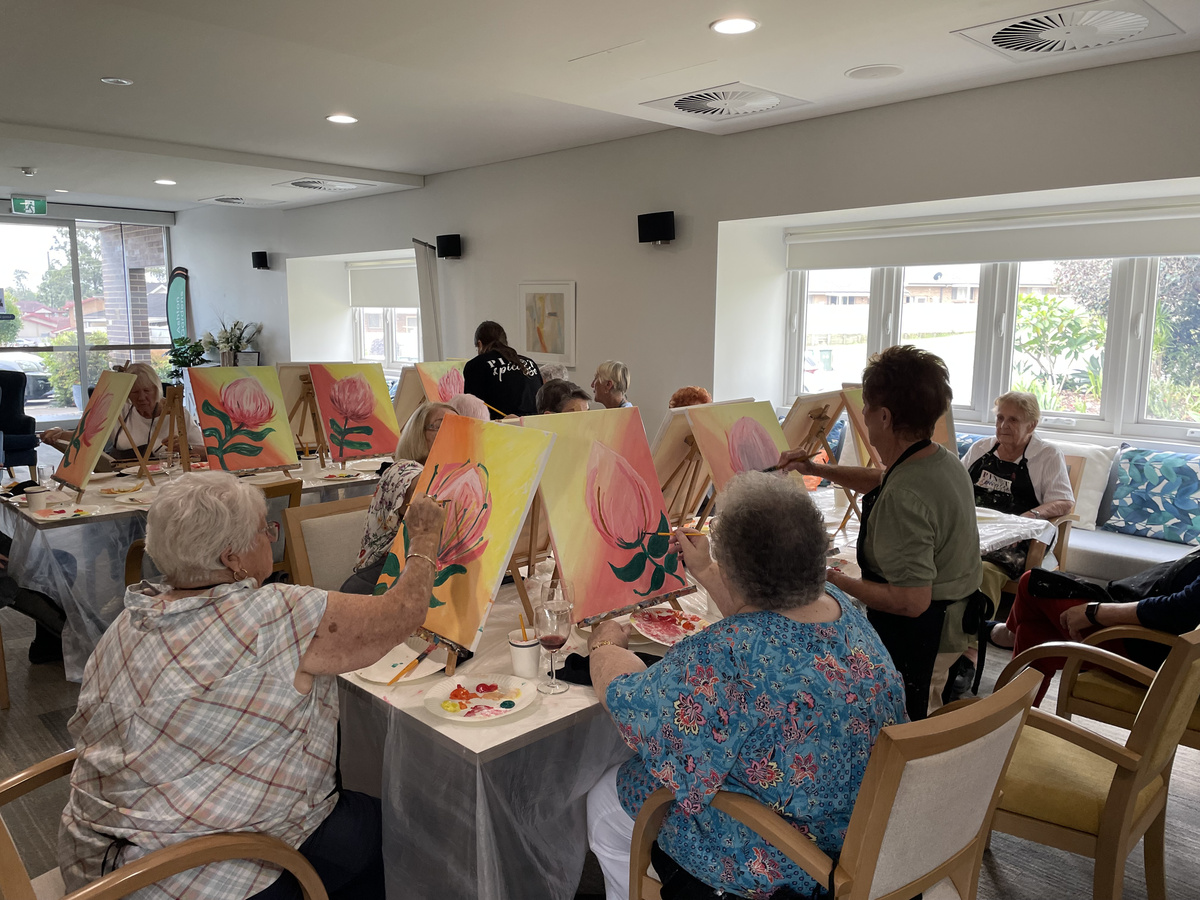  A group of residents painting their respective canvases mounted on easels