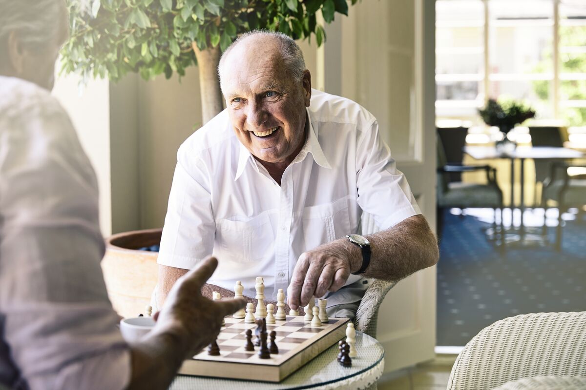 Couple of senior men playing chess and laughing