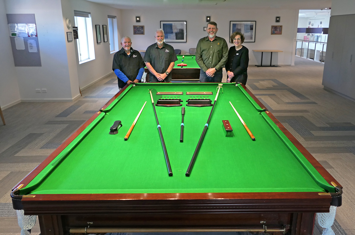 Residents and staff posing with their brand new pool cues and sticks
