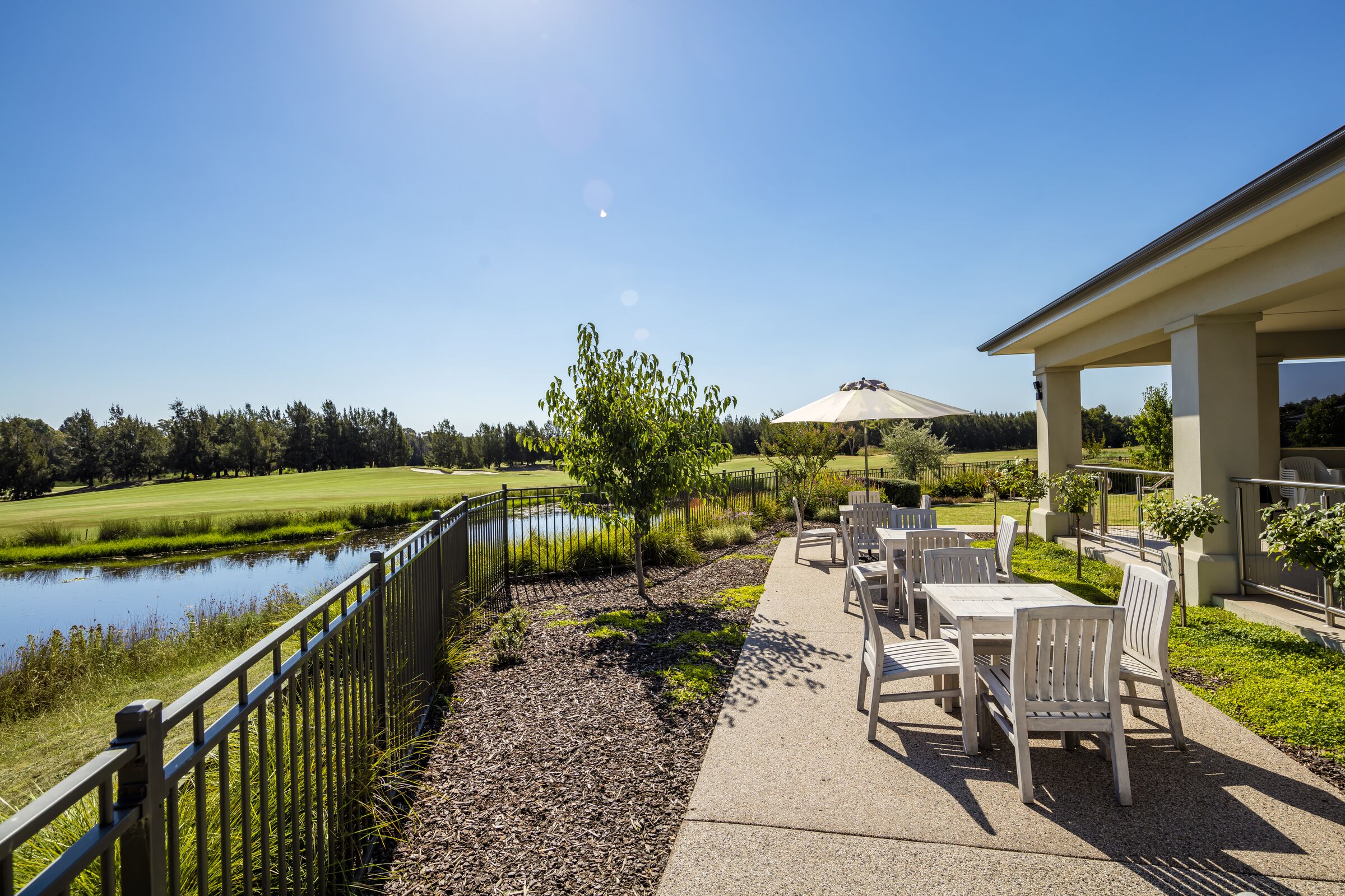 The Links at Waterford covered terrace with seating overlooking golf course lake