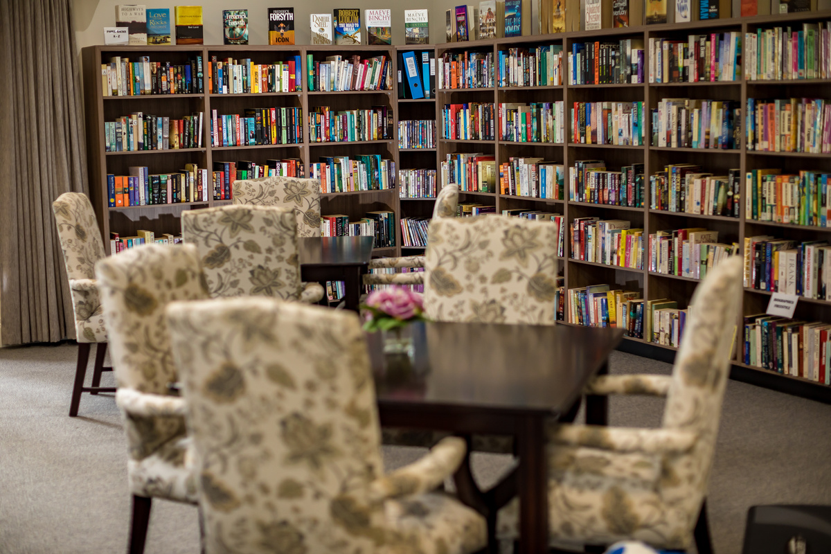 Port Phillip Village library room with well stocked bookcases, tables and chairs