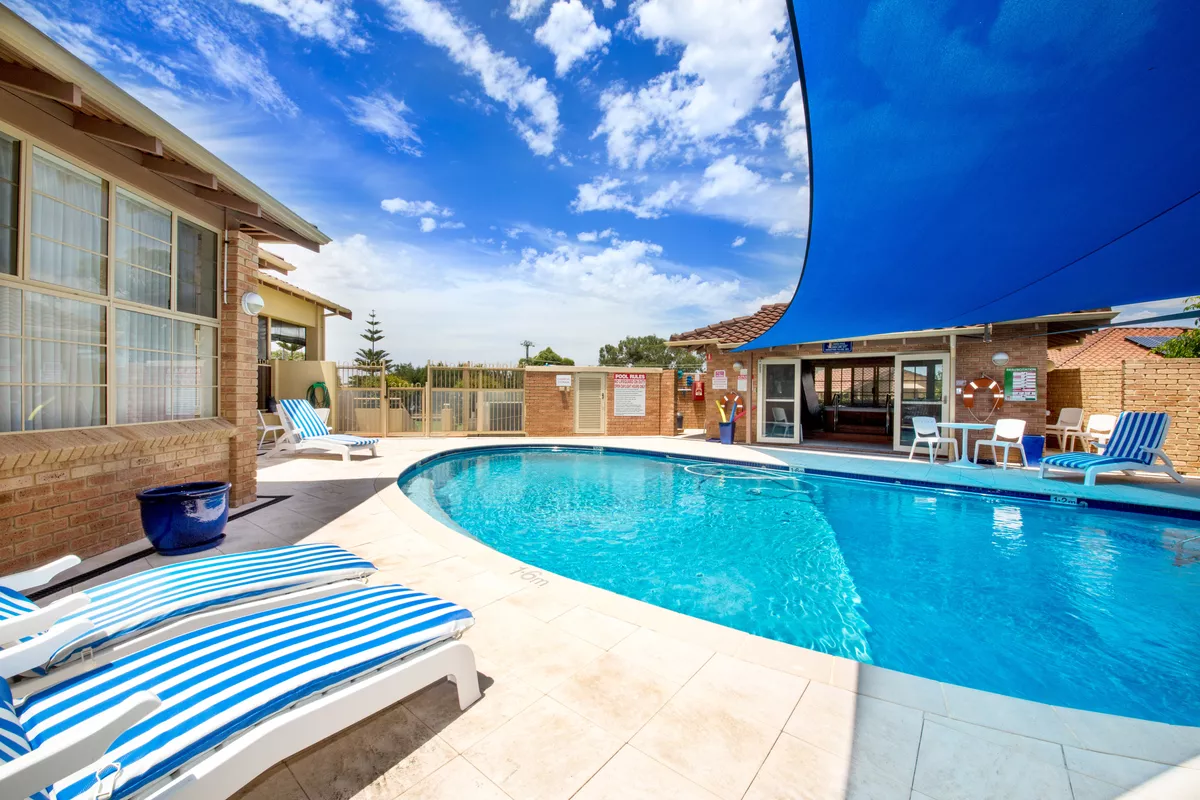 Parkland Villas Mandurah outdoor swimming pool with shaded poolside seating and pool lounges